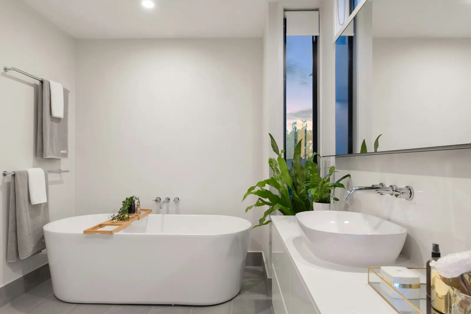 Freestanding bath and countertop basin in a light bathroom
