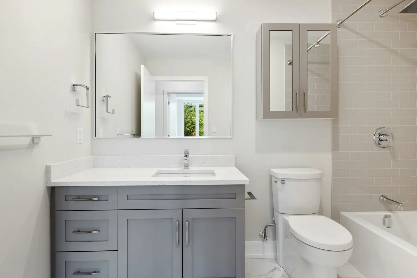 Bathroom with a grey vanity unit, toilet and bath