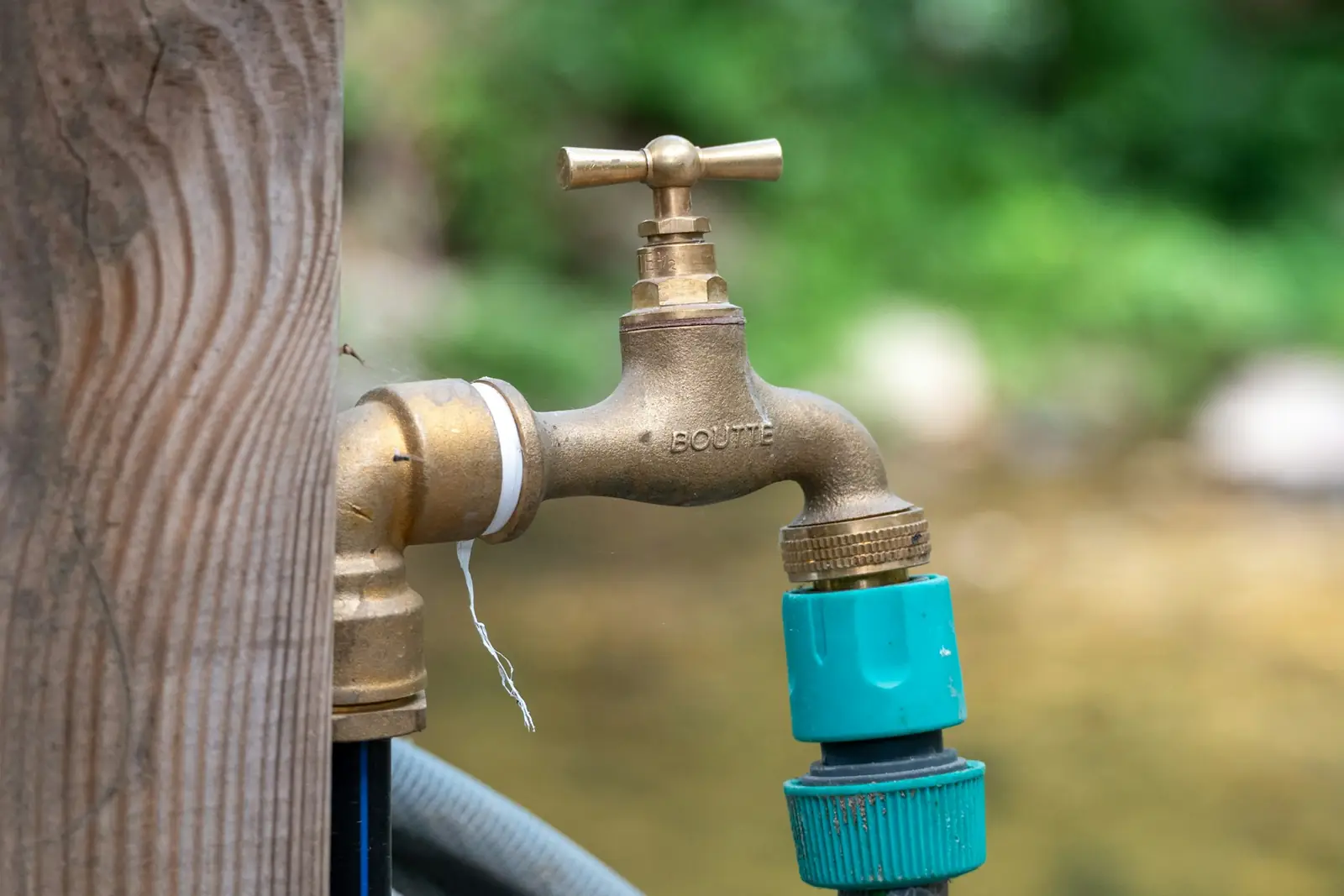 Brass outside tap with a hose connector on a garden post