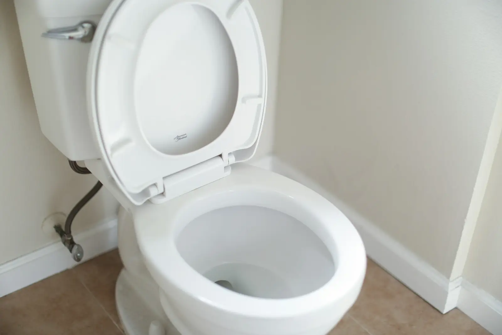 Close-coupled toilet with the seat raised and cistern behind