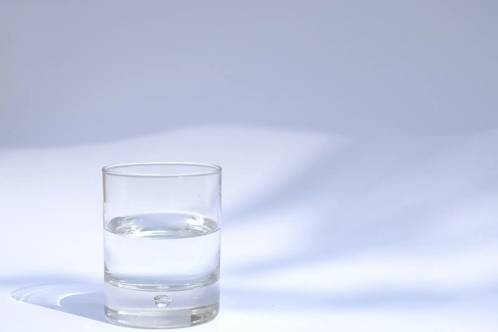 Glass of clear tap water on a white surface