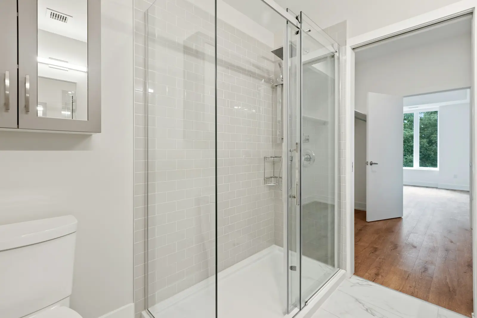 Frameless glass shower enclosure in a bright bathroom