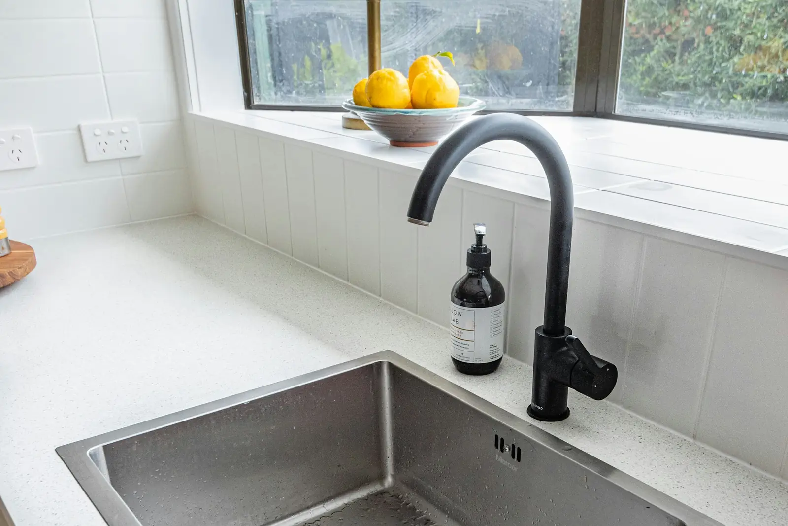 Stainless steel undermount kitchen sink with a black mixer tap