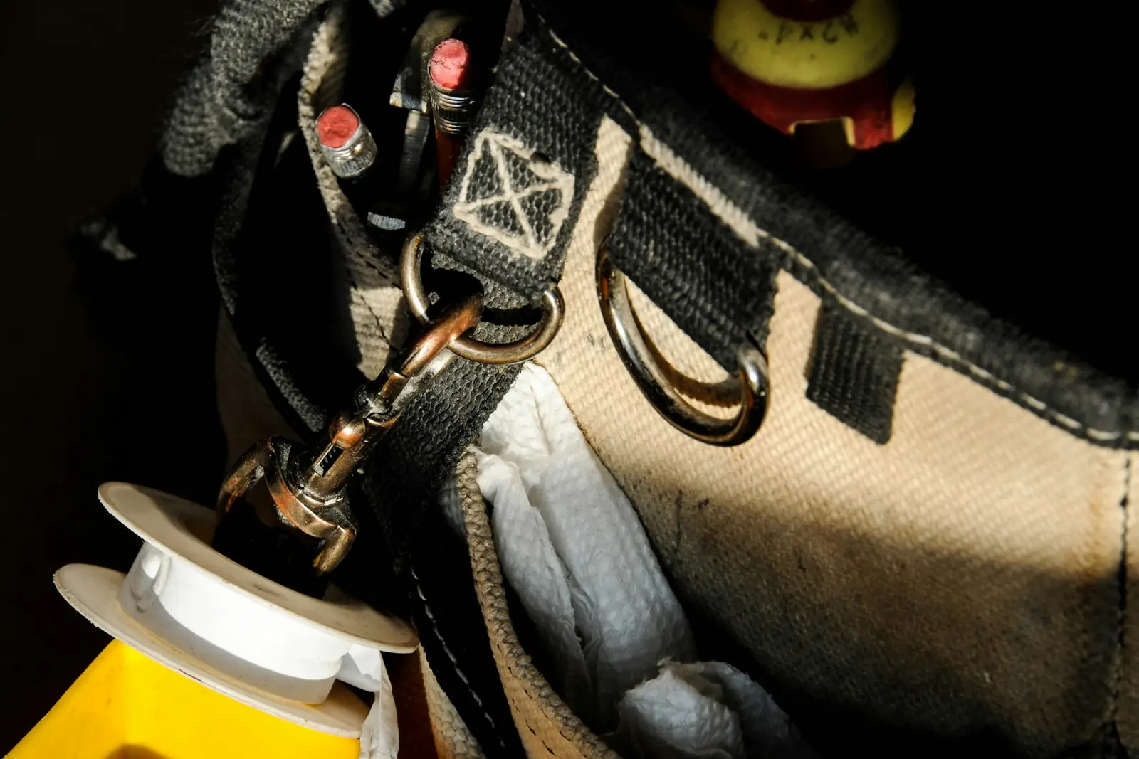 Close-up of a plumber's tool bag with fittings and hand tools
