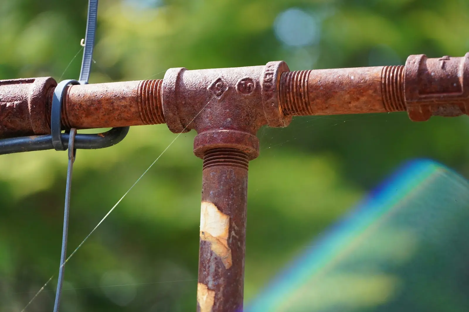 Rusty T-joint on an old metal pipe