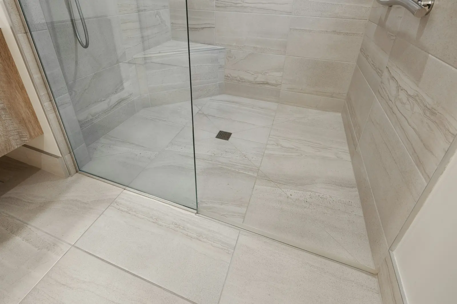 Level-access wet room floor with a glass screen and floor drain