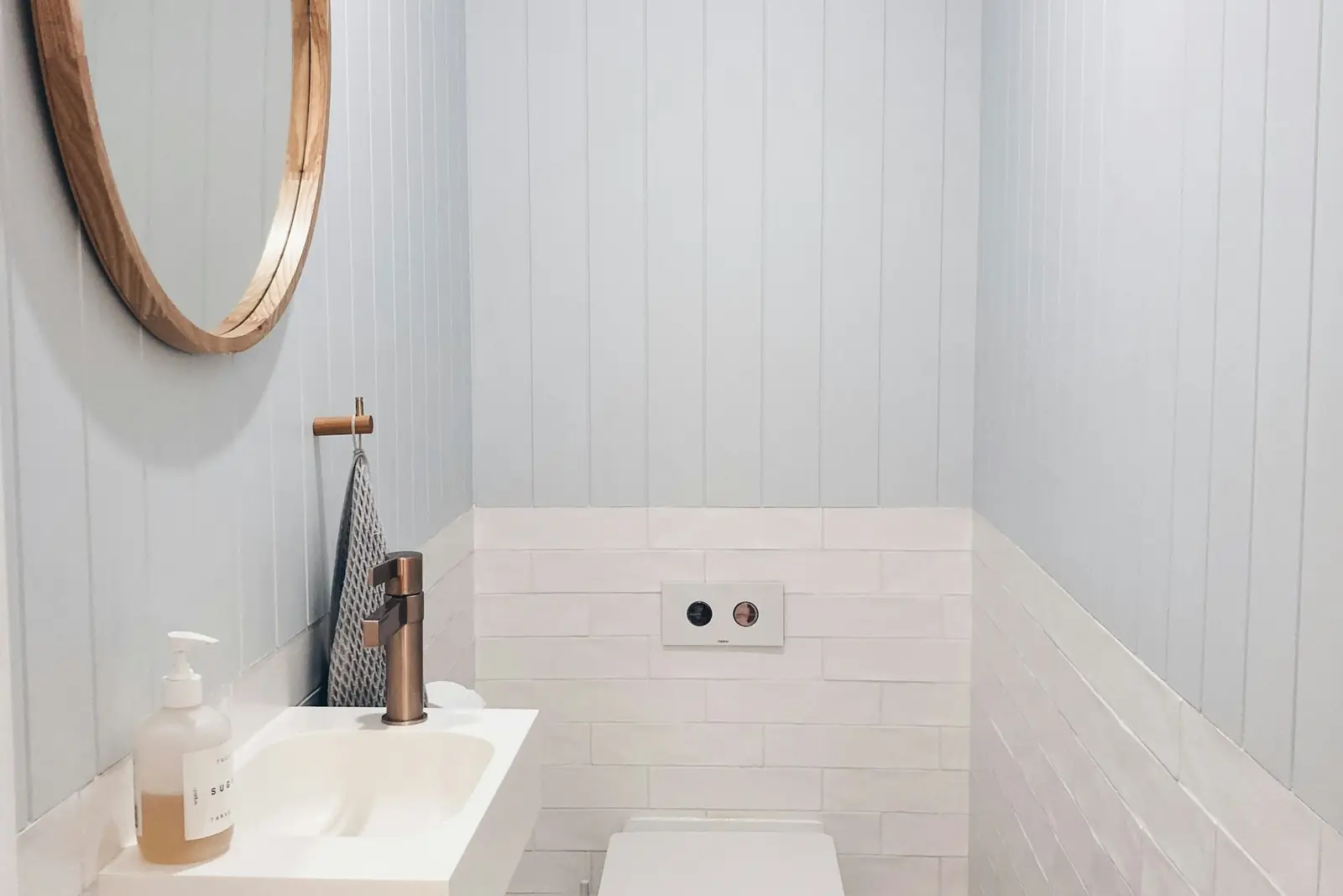 Cloakroom with a wall-mounted flush plate for a concealed cistern and small basin