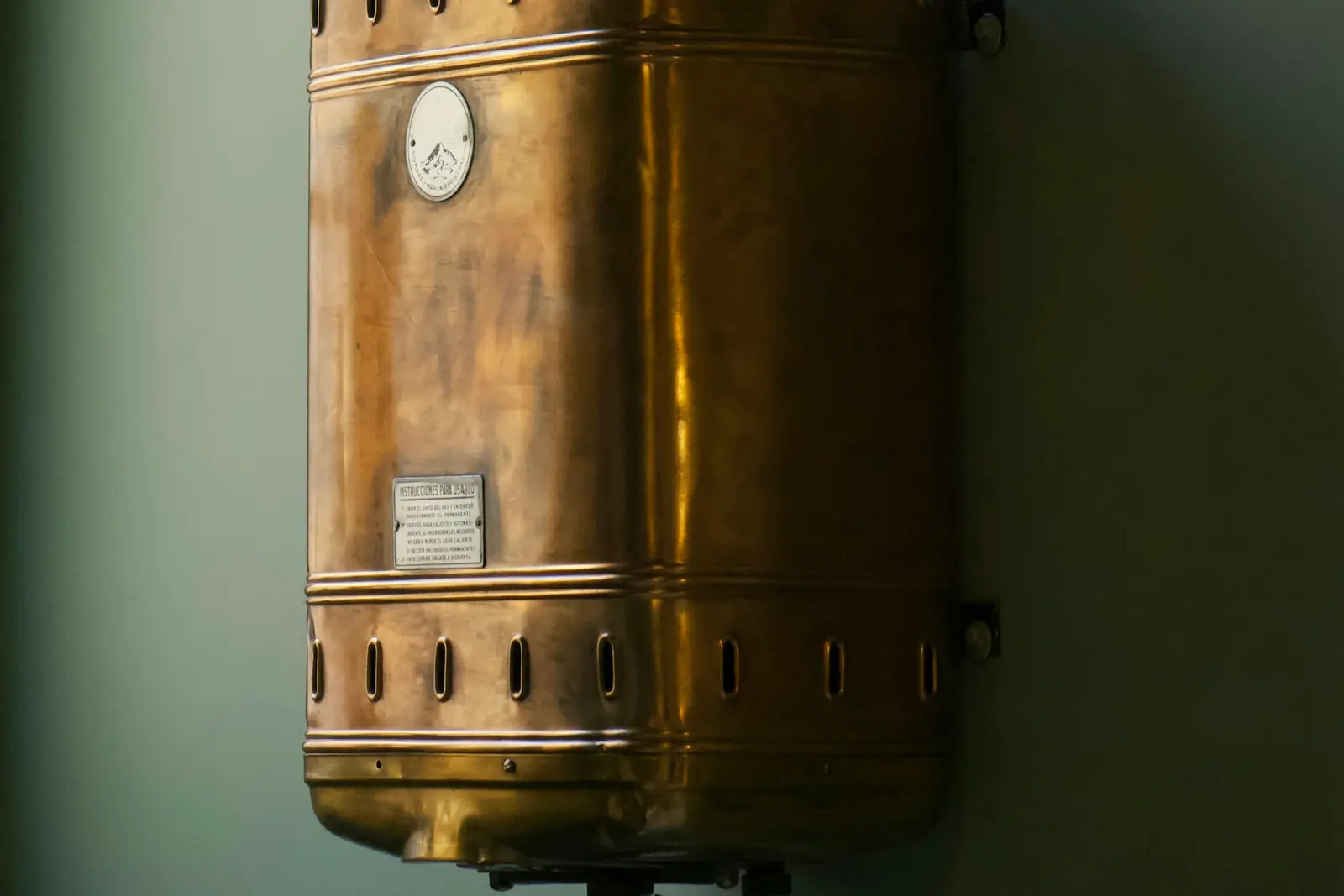 Old copper water heater mounted on a wall