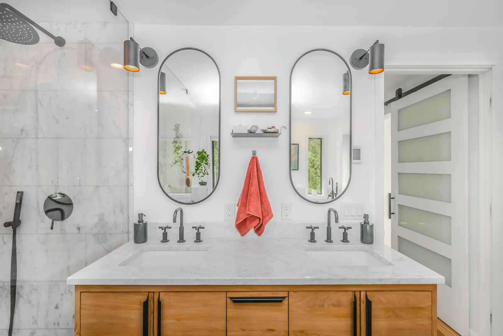 Bathroom with a double vanity, two mirrors and wall-mounted shower controls