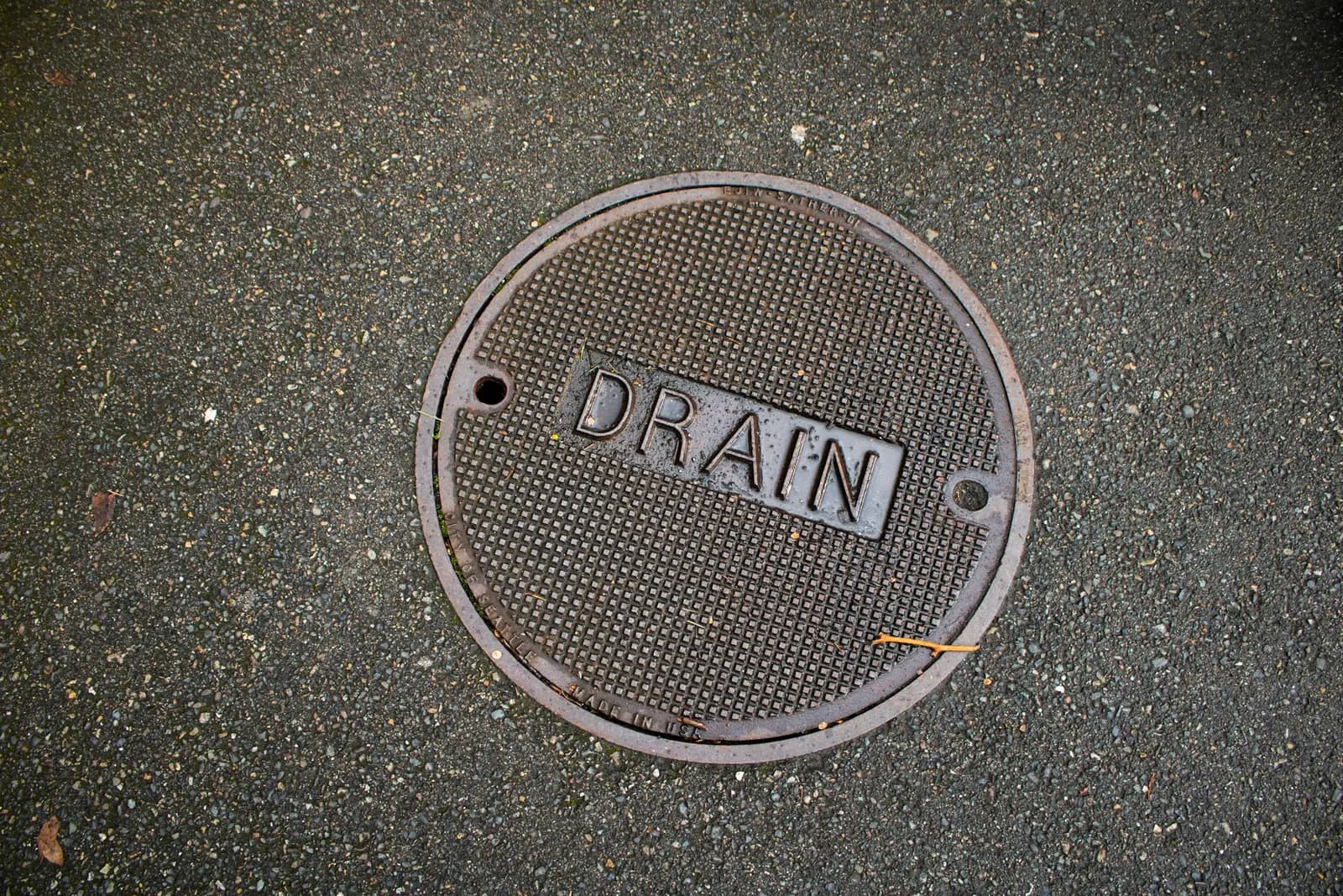 Round metal drain cover set into the ground