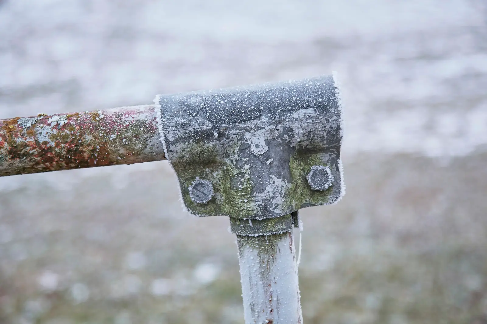Frost covering an outdoor pipe and bracket in winter