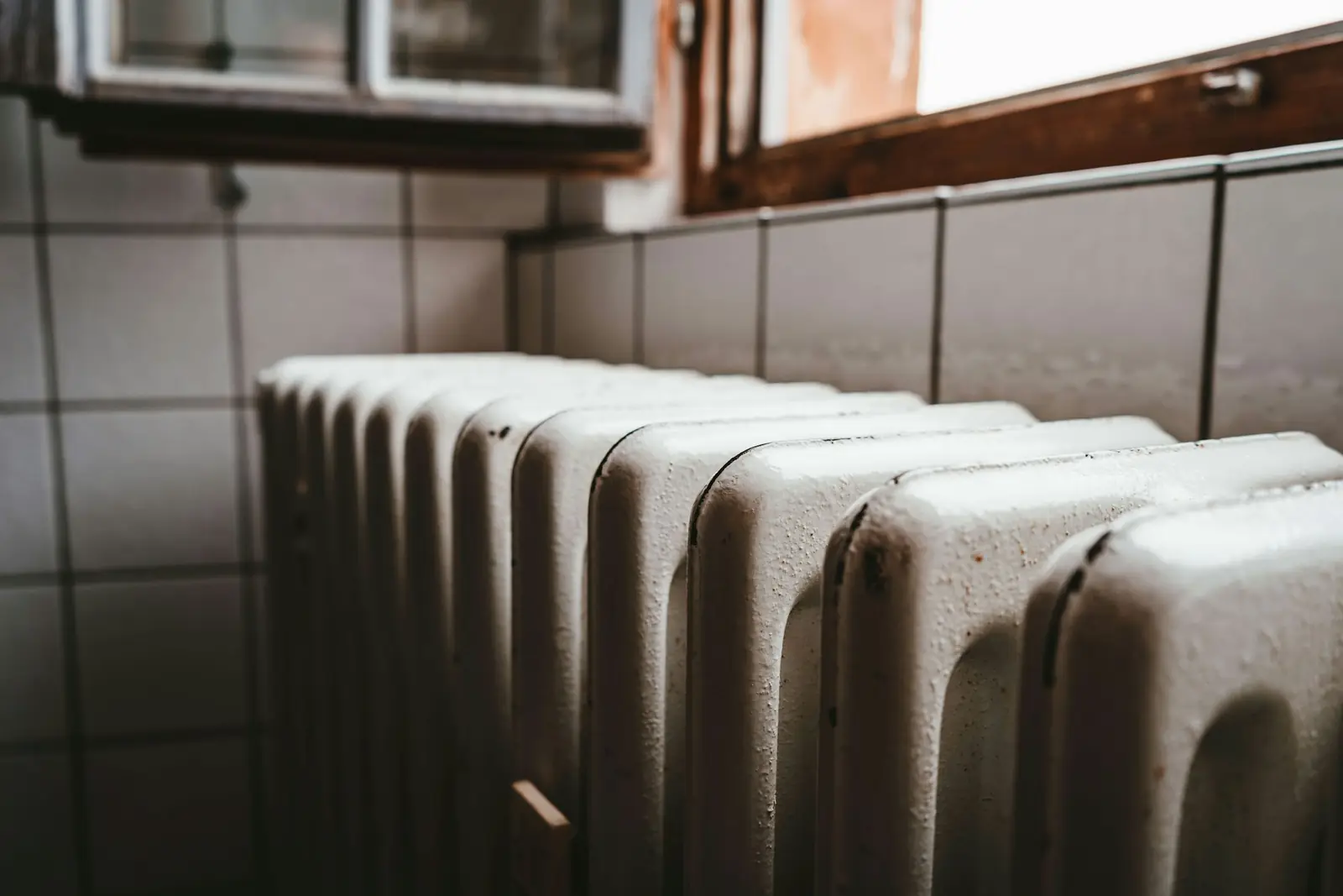 Old cast iron radiator beneath a window