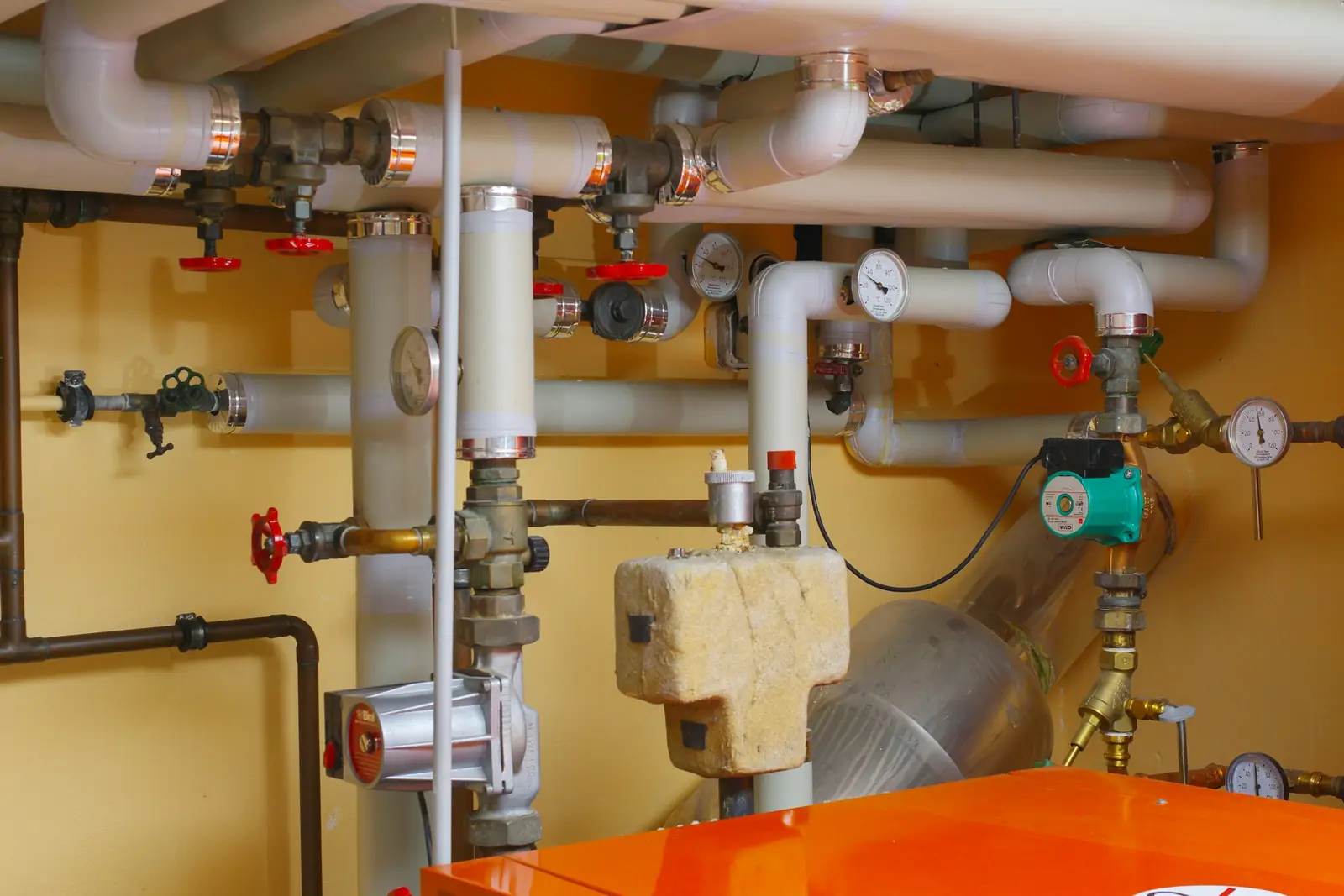 Pipework with isolating valves, pressure gauges and a pump in a plant room