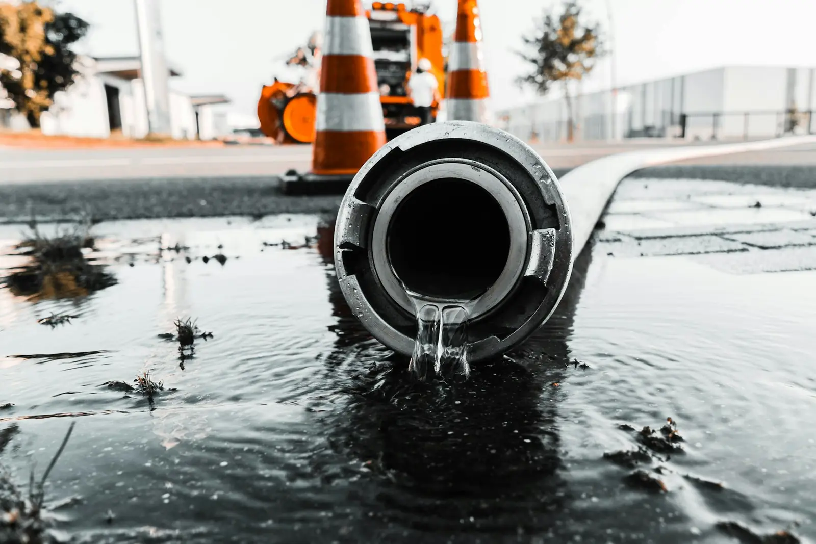 Water pouring from a burst pipe and flooding the ground